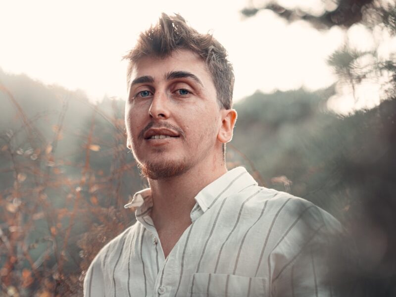 a man standing in front of some bushes