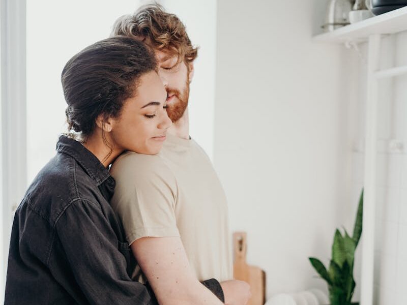 Young couple embracing in a cozy kitchen, sharing a moment of love and affection.