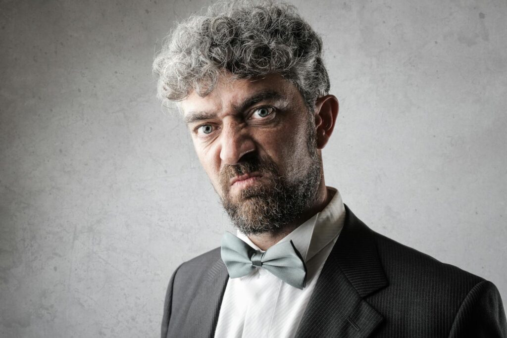 Close-up shot of a serious bearded man in formal wear. Studio photography.