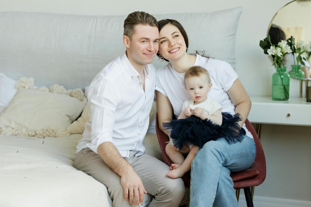 A joyful family moment with parents and their baby, captured in a cozy home environment.