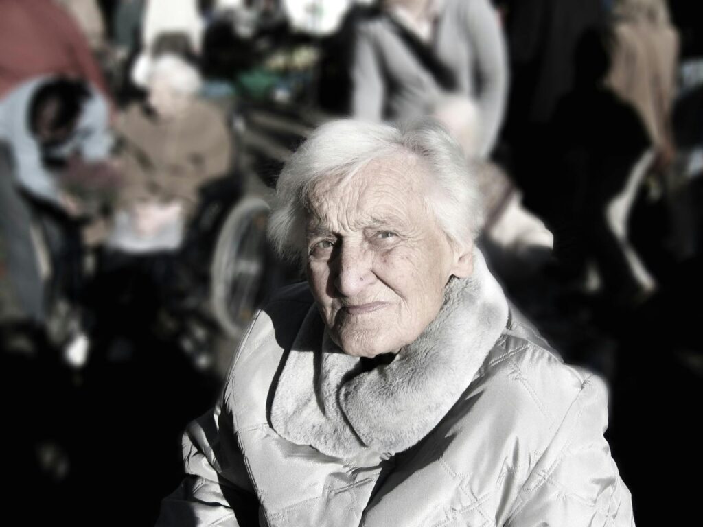Portrait of an elderly woman in a winter coat. Outdoor setting with a blurred background.