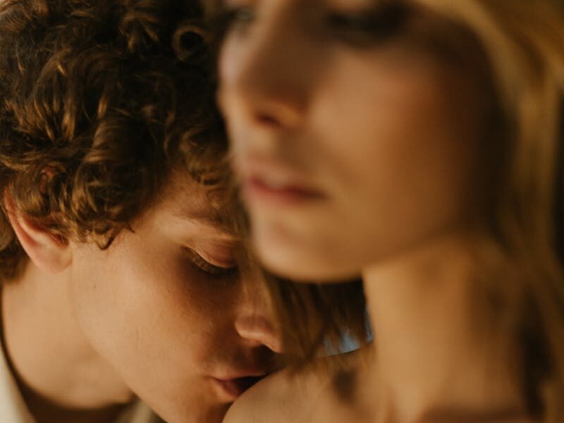 A romantic couple sharing a tender and intimate moment indoors, capturing the essence of love.