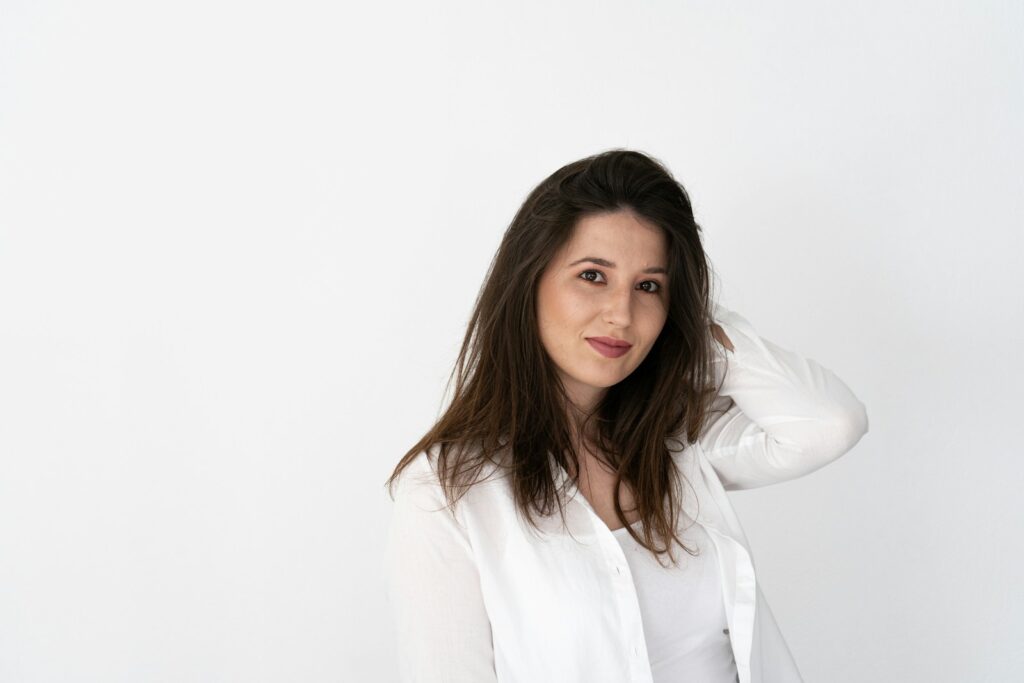 a woman in a white shirt is posing for a picture
