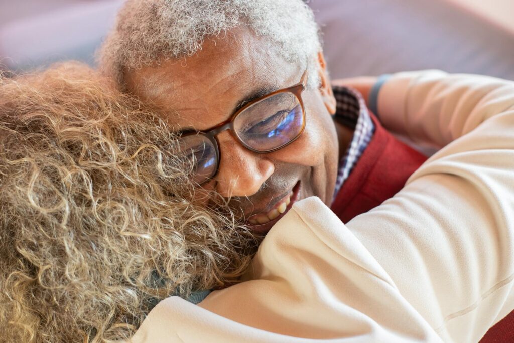 Heartwarming close-up of a senior couple embracing joyfully, showcasing love and happiness.
