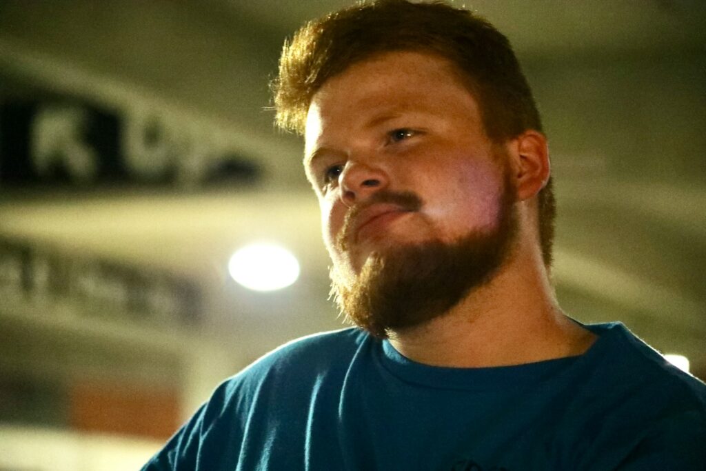 A man with a beard looks to the side.