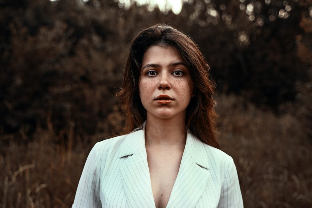 a woman in a white suit standing in a field