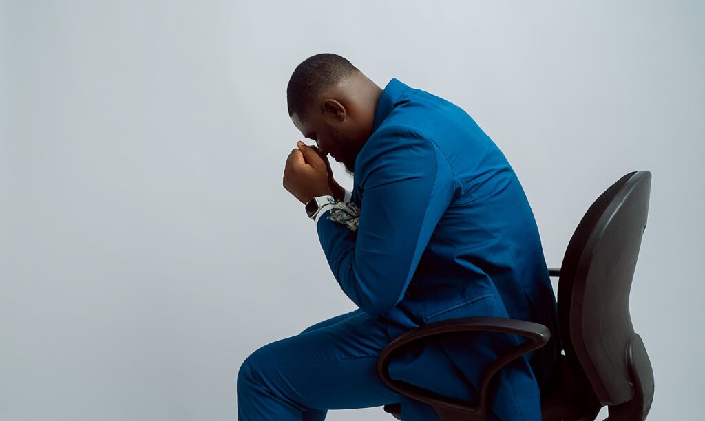 a man in a blue suit sitting on a black chair