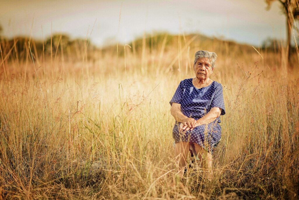woman sitting on chair and surrounded by grass