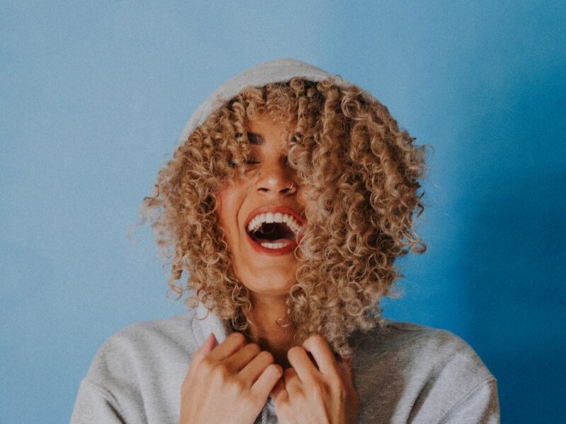 smiling woman wearing gray hoodie