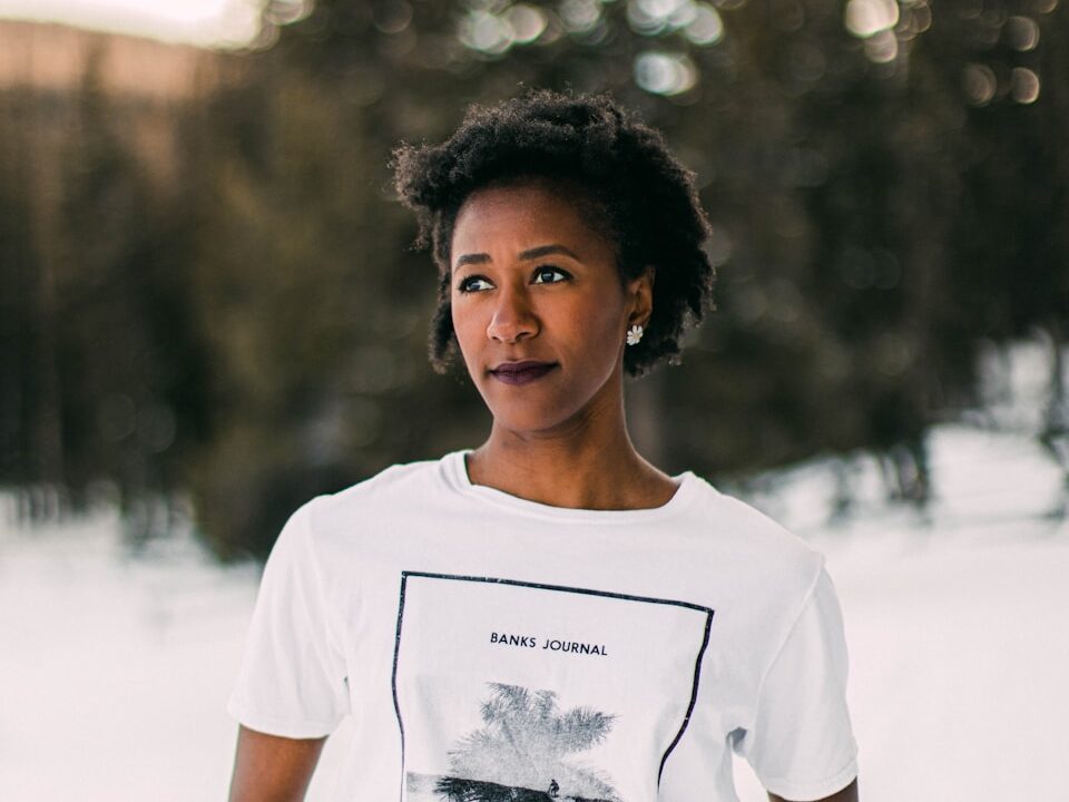 woman in white crew neck t-shirt standing on white sand during daytime