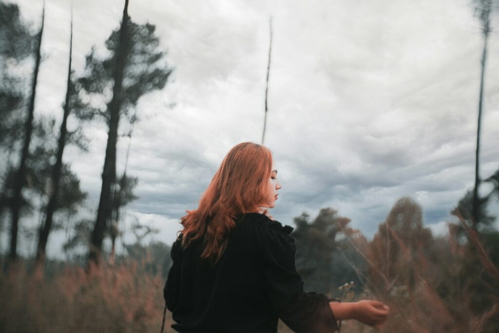 a woman standing in a field of tall grass