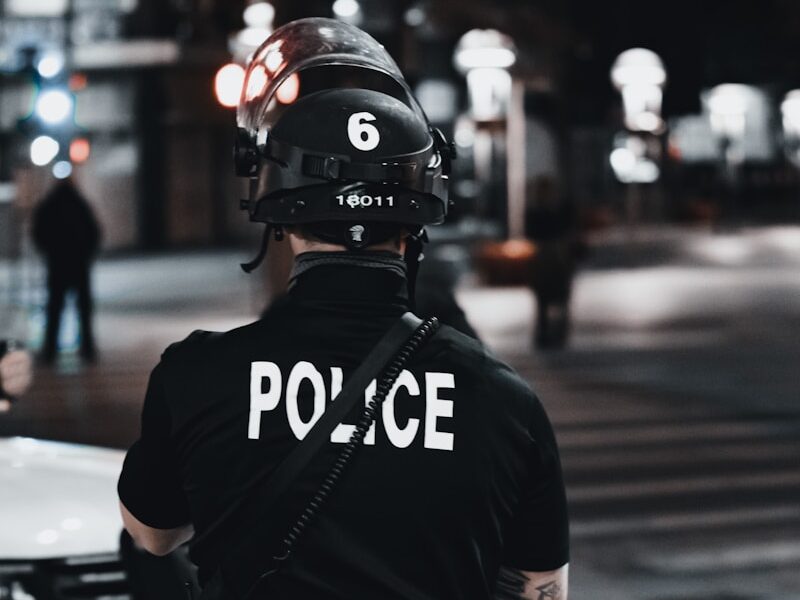 man in black and white adidas jacket and black helmet standing on road during daytime