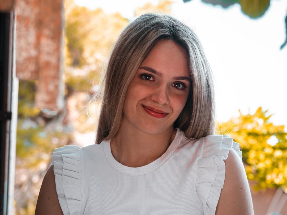 a woman in a white top is posing for a picture