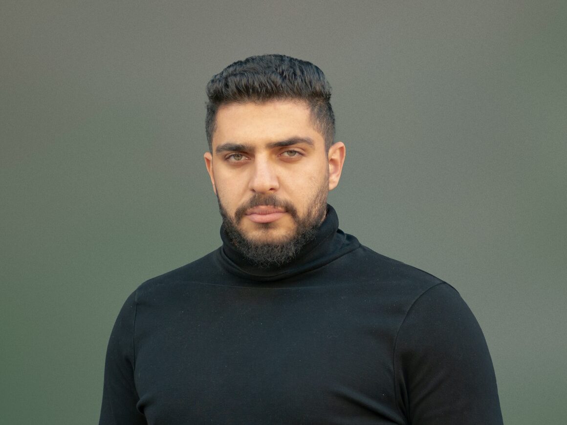 a man wearing a black turtle neck sweater