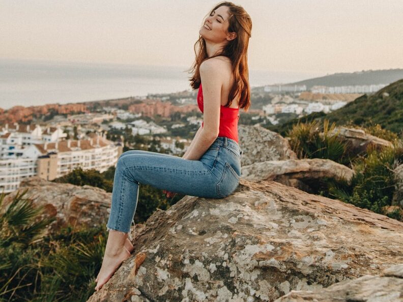 woman sitting on rock during daytime