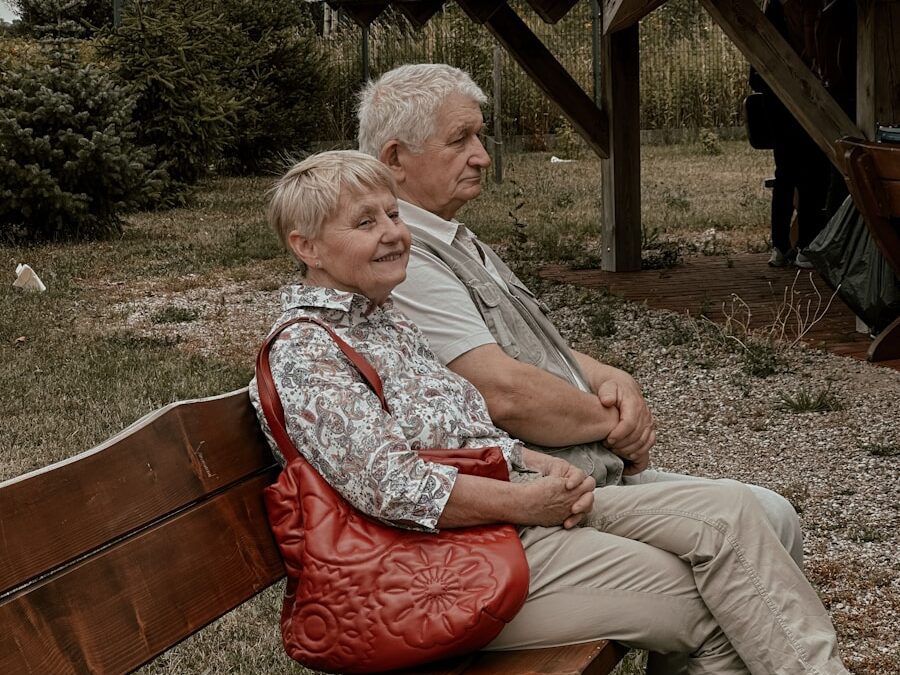 a man and a woman sitting on a wooden bench