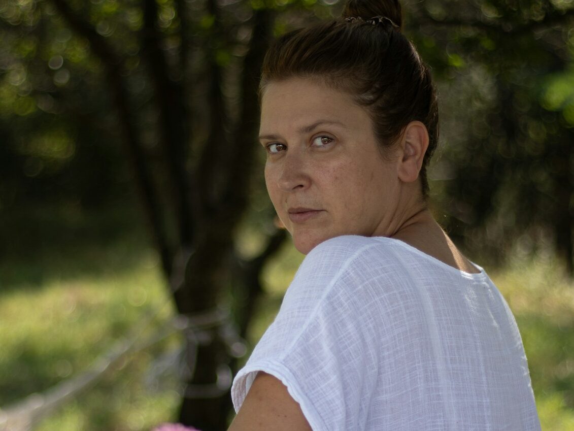 a woman sitting in a hammock in a park