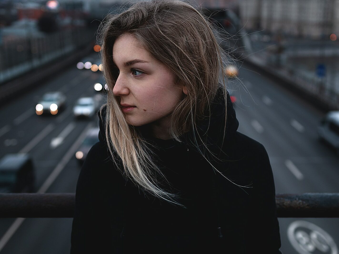 woman in black hoodie on bridge