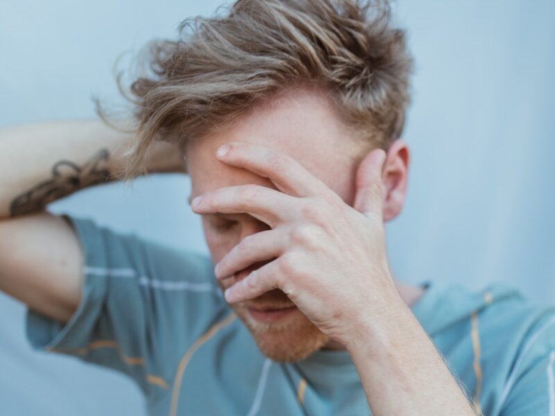 man in blue crew neck t-shirt holding brown rope