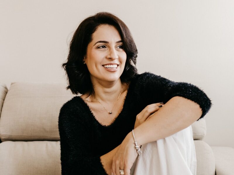 woman in black long sleeve shirt sitting on white couch