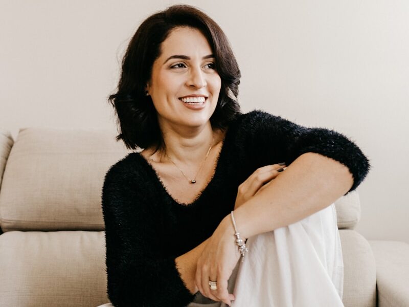 woman in black long sleeve shirt sitting on white couch