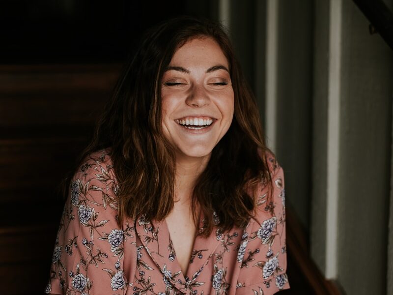 woman sitting on wooden stair smiling