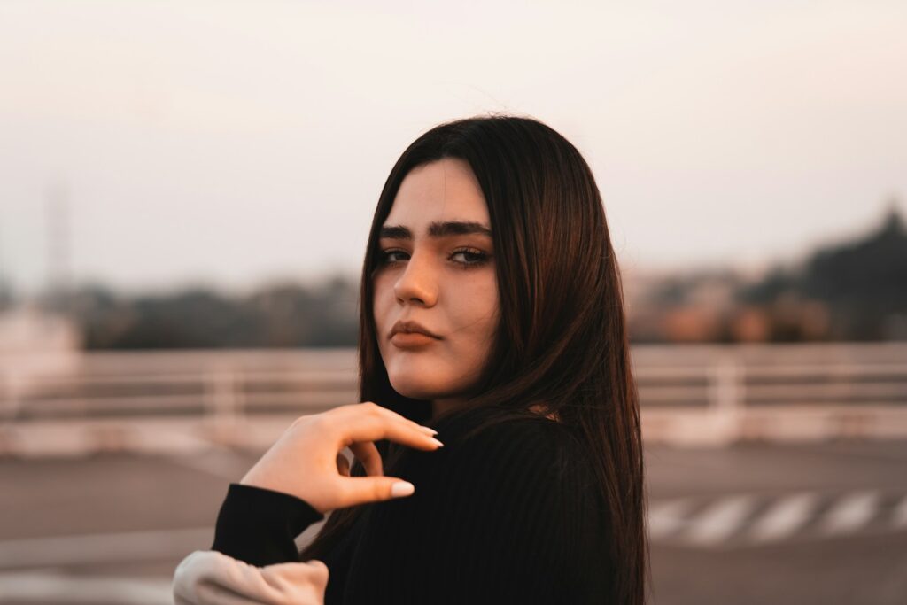 a woman with long brown hair is posing for a picture