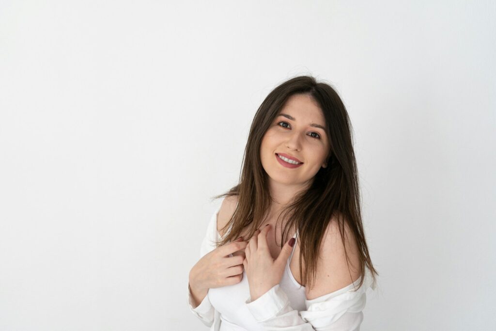a woman posing for a picture with her hands on her chest