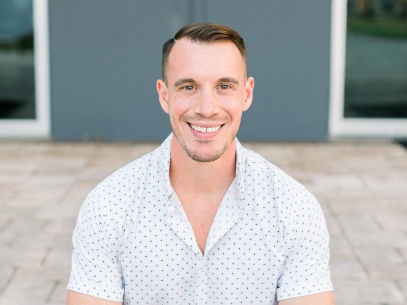 a man sitting on the ground in front of a door