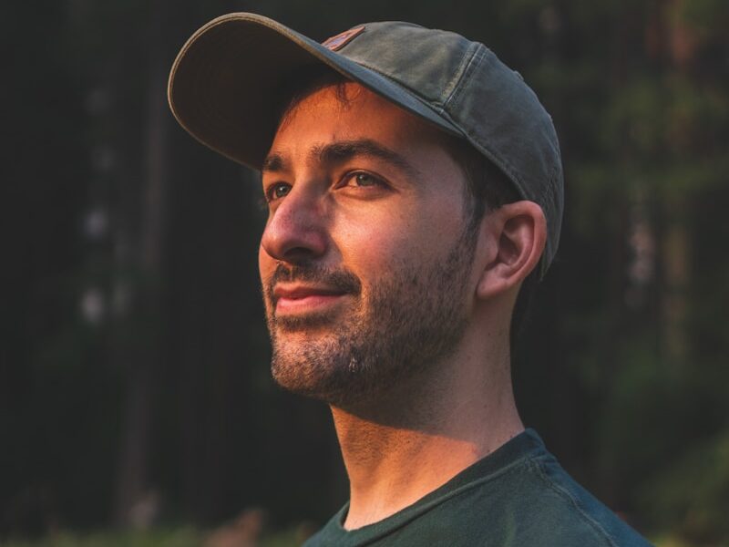 man in black crew neck shirt wearing black hat