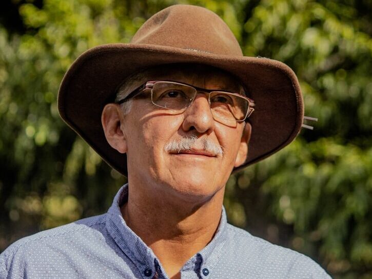 man in gray button up shirt wearing brown fedora hat