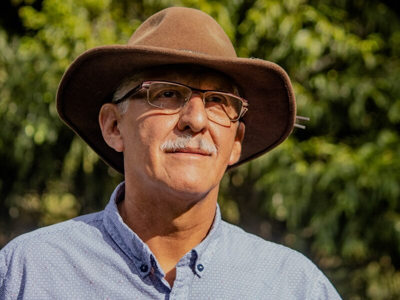 man in gray button up shirt wearing brown fedora hat