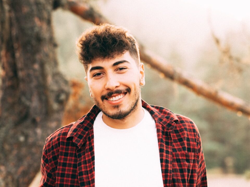 a man standing in front of a tree smiling