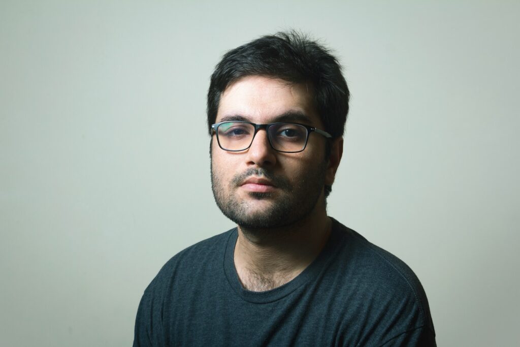 man in black crew neck shirt wearing black framed eyeglasses