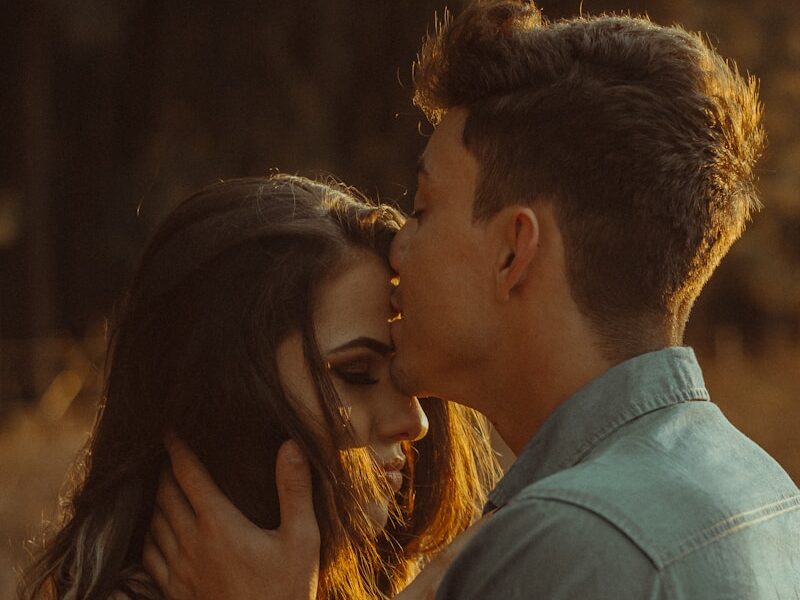 man kissing woman forehead