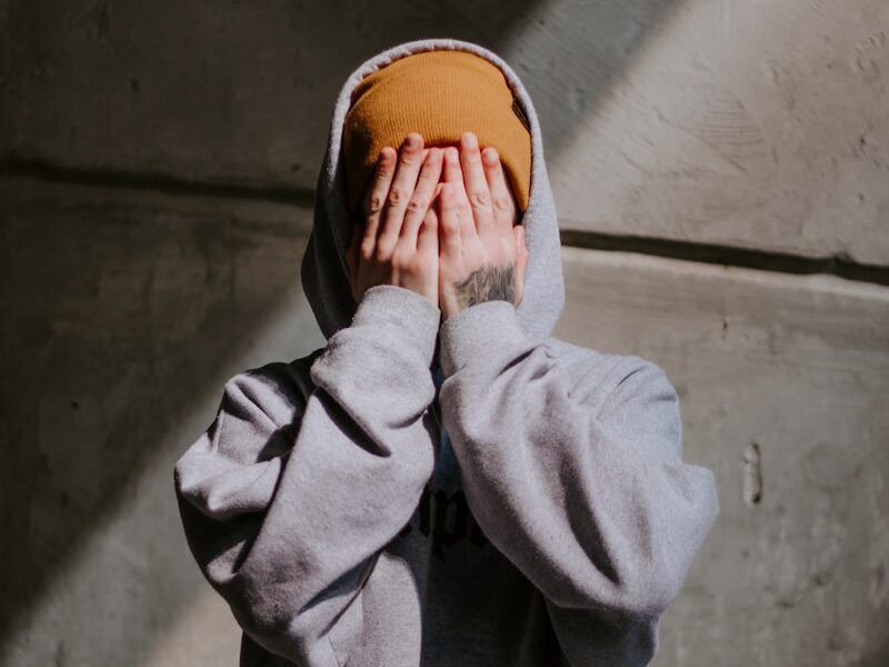 person in gray hoodie wearing brown leather shoes