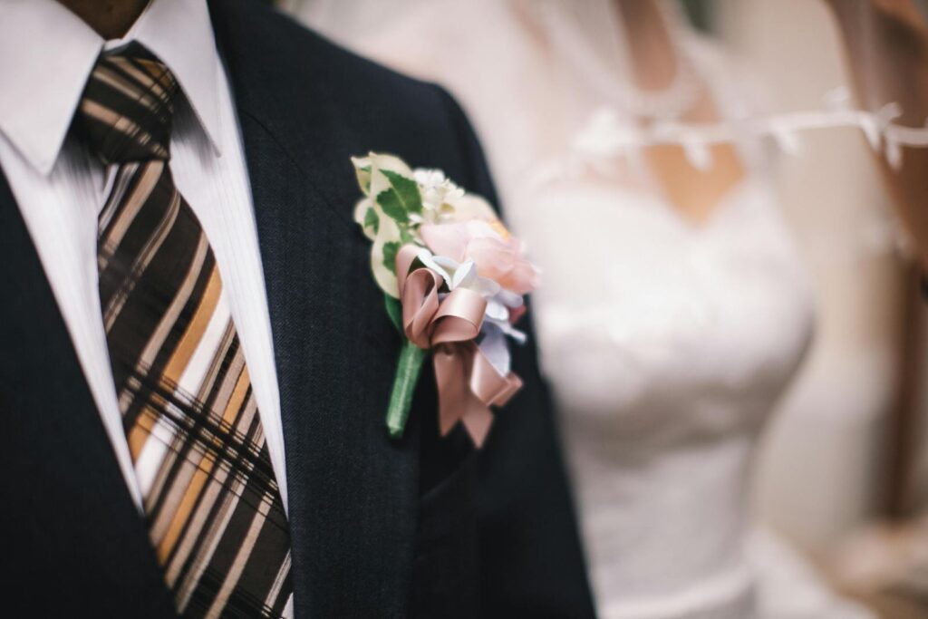 Close-up of a bride and groom in formal wedding attire, highlighting details.