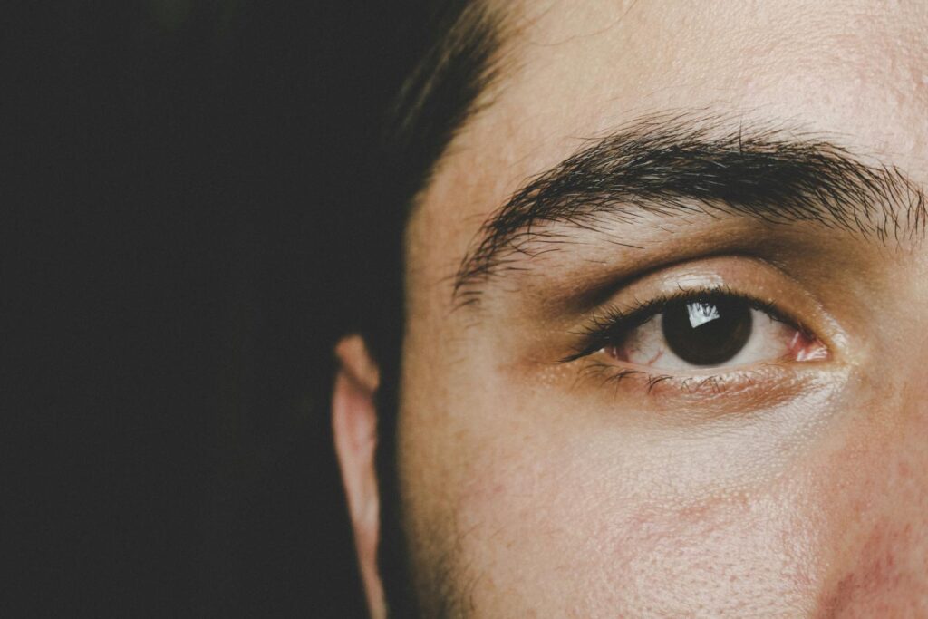 Detailed close-up of a man's eye highlighting natural eyebrow and skin texture.