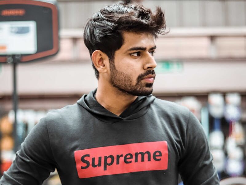 Portrait of a young man holding a basketball on an indoor court in Ahmedabad, India.
