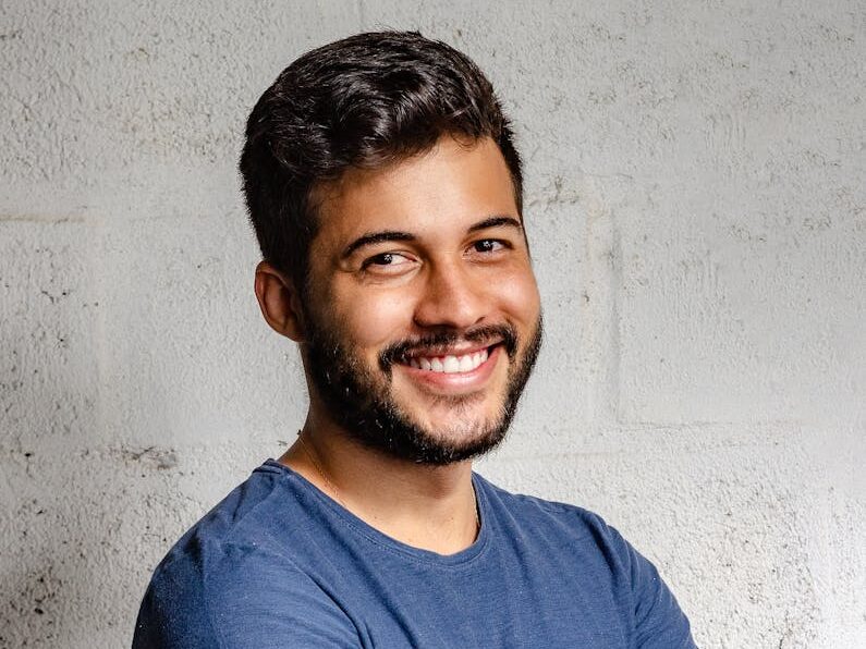 Portrait of a happy man with arms crossed, exuding confidence and friendliness.