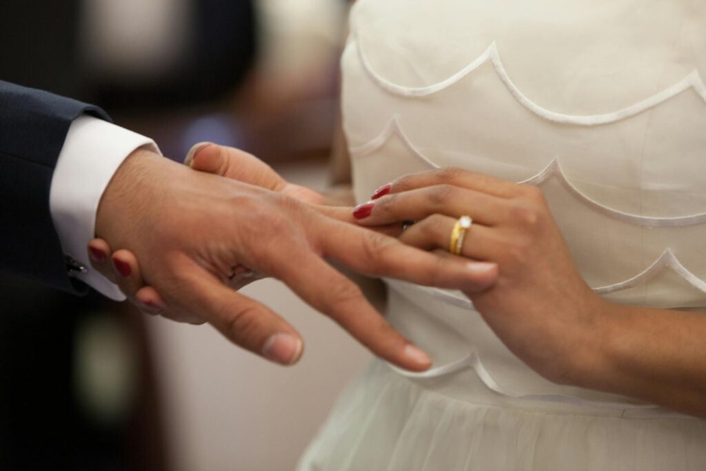 Close-up of a bride and groom exchanging rings during their wedding ceremony, symbolizing love and unity.