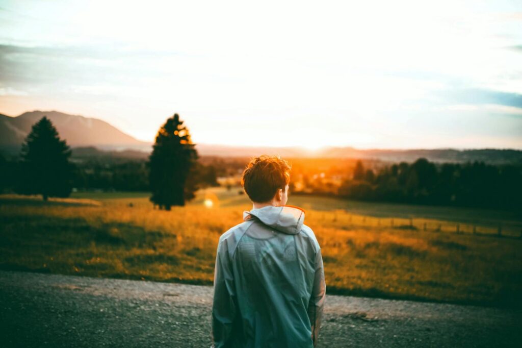 A young man enjoys a serene sunset view in Ohlstadt, Germany, surrounded by nature.