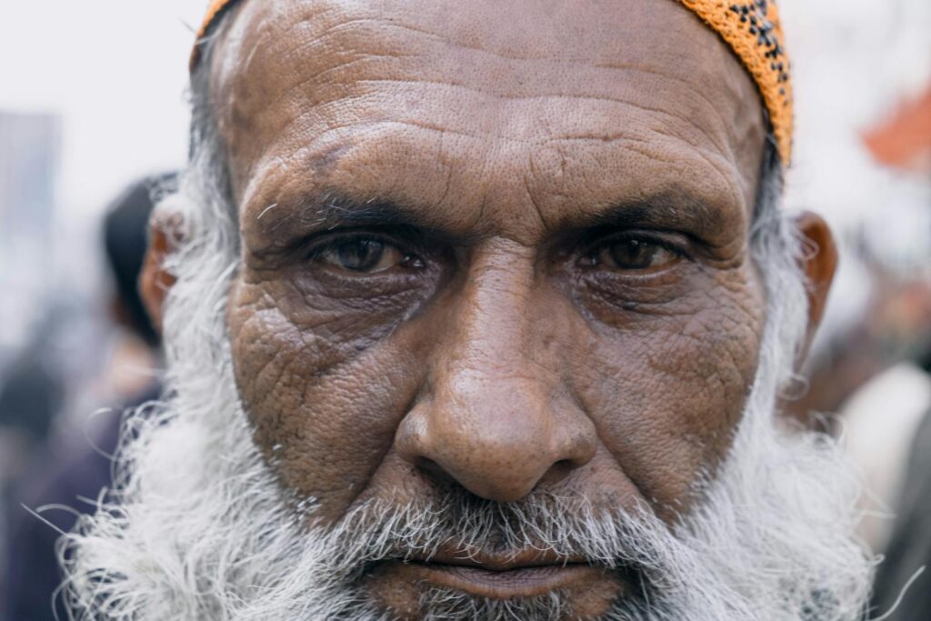 Intimate close-up capturing the wrinkles and wisdom of an elder South Asian man.