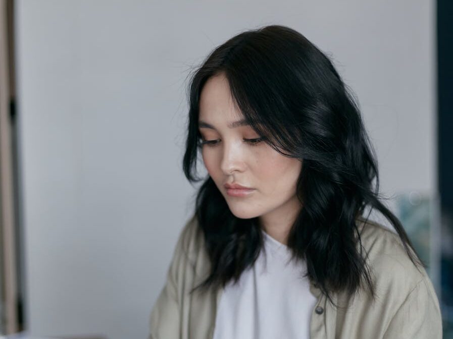 Focused young woman working on a laptop at her desk, managing finances.