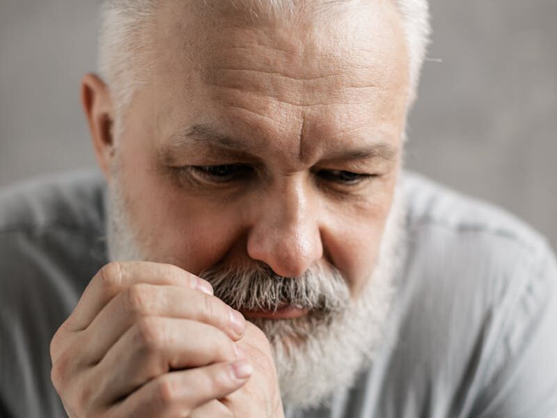 Portrait of an elderly man with gray hair and a pensive expression, contemplating deeply.