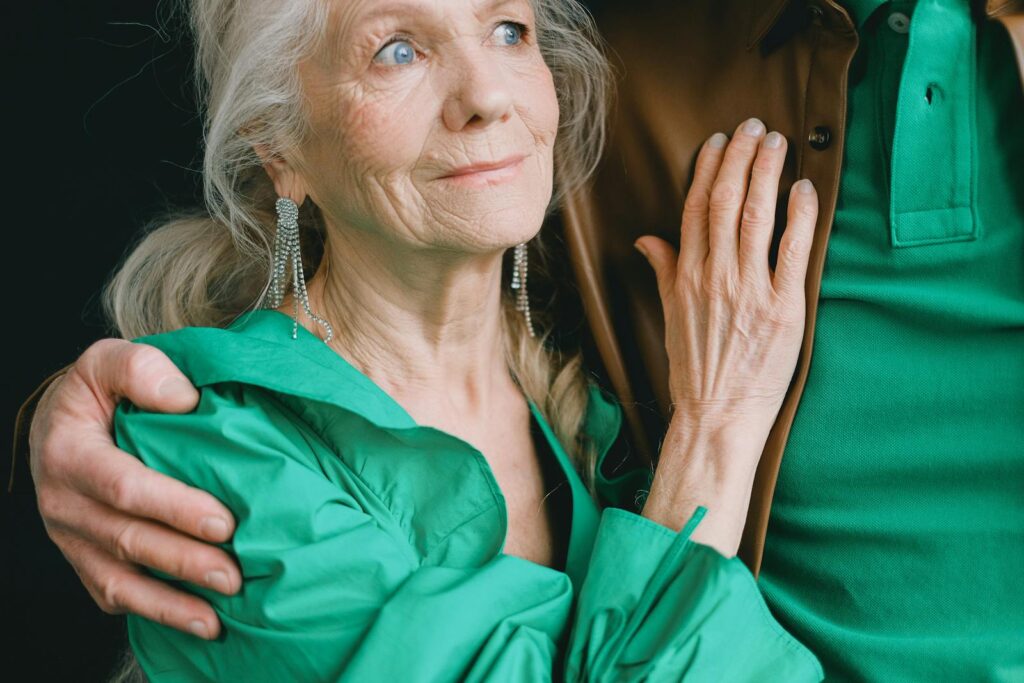 A warm embrace captures an elderly woman in green, exuding love and comfort.