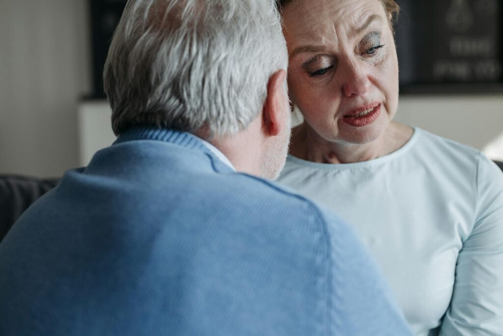 A senior couple sharing an emotional moment, showing support and empathy indoors.