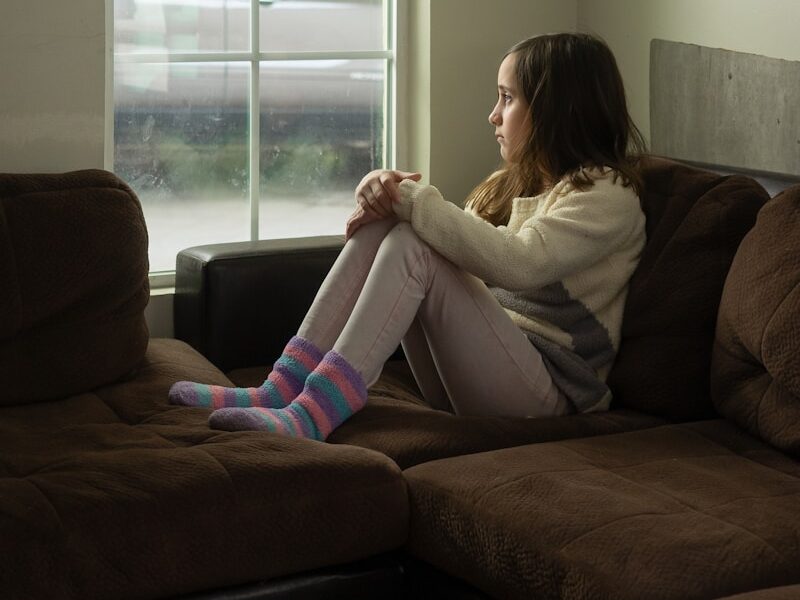 woman in white long sleeve shirt sitting on black couch