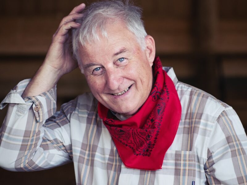 man in white and black plaid dress shirt wearing red scarf
