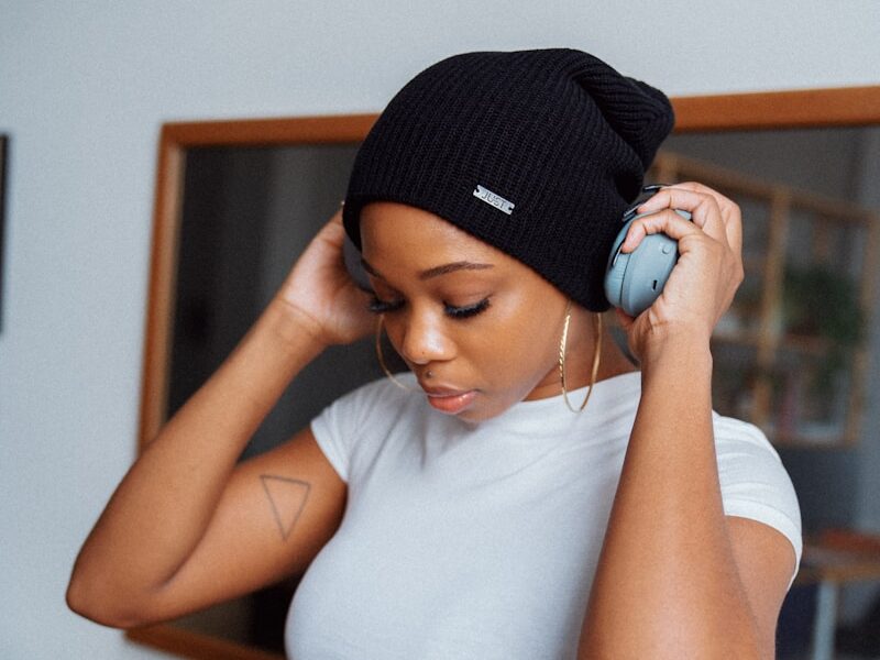 woman in white tank top and black knit cap